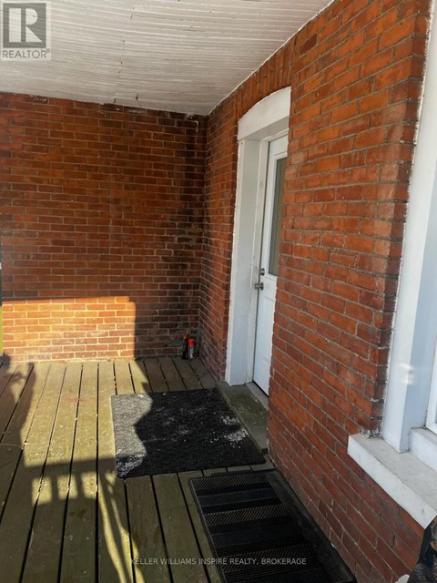 A brick wall with a door and a window.