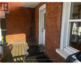 A small porch with a black mat and a white door.