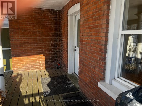 A small porch with a black mat and a white door.