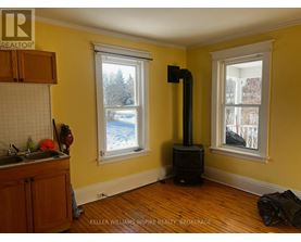 A wood stove is in a room with yellow walls.