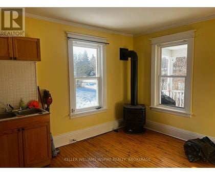 A wood stove is in a room with yellow walls.