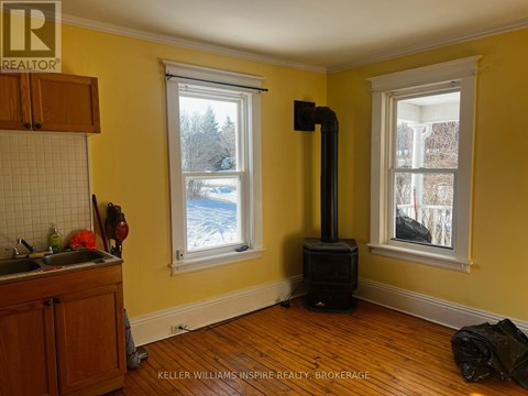 A wood stove is in a room with yellow walls.
