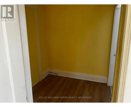 A room with yellow walls and wooden floors.