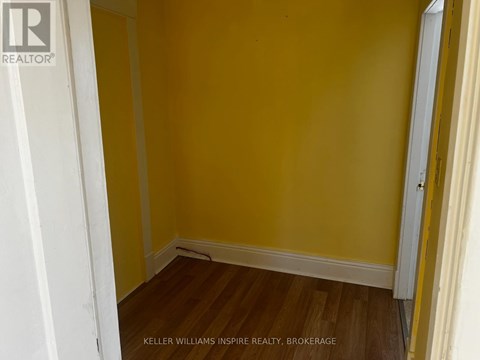 A room with yellow walls and wooden floors.