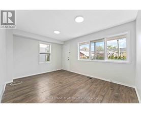 A room with a large window and wooden flooring.