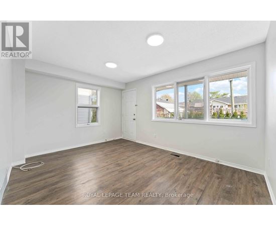 A room with a large window and wooden flooring.