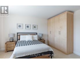 A bedroom with a bed, nightstands, and a wardrobe.