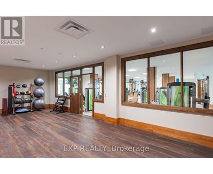 A spacious room with wooden floors and a large mirror on the wall.