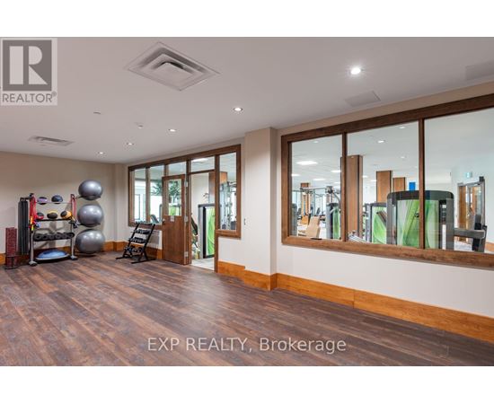 A spacious room with wooden floors and a large mirror on the wall.