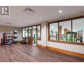 A spacious room with wooden floors and a large mirror on the wall.