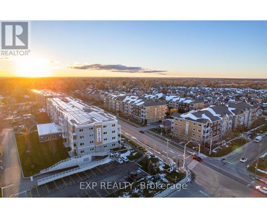A sunset view of a residential area with apartment buildings and a road.