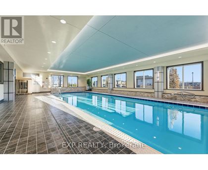 A large indoor swimming pool with tiled floors and walls.