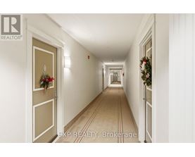 A long hallway with a Christmas wreath on the door.