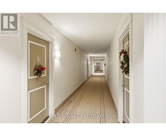 A long hallway with a Christmas wreath on the door.
