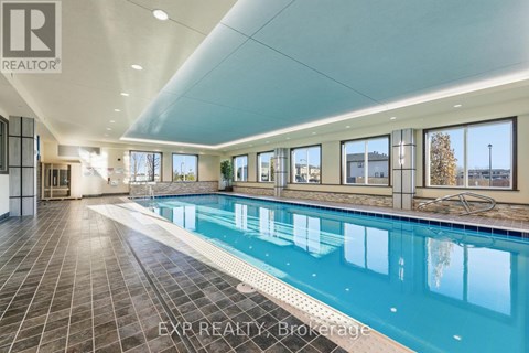 A large indoor swimming pool with tiled floors and walls.