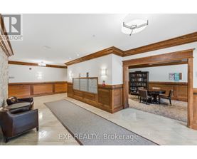 A well-lit office lobby with a reception desk and a bookshelf.
