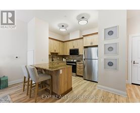 A kitchen with wooden cabinets and a stainless steel refrigerator.