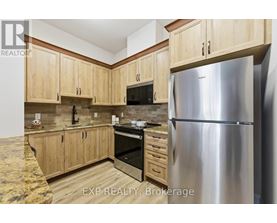 A kitchen with wooden cabinets and a stainless steel refrigerator.