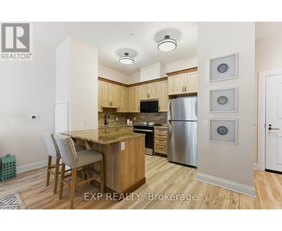 A kitchen with wooden cabinets and a stainless steel refrigerator.