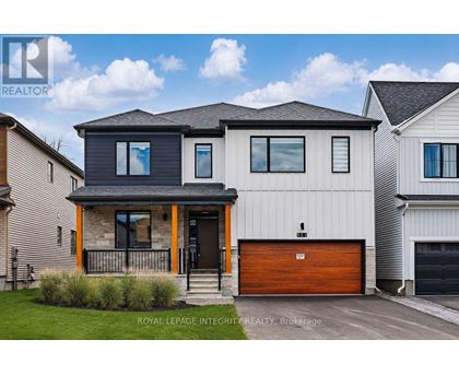 A modern house with a garage door is for sale.