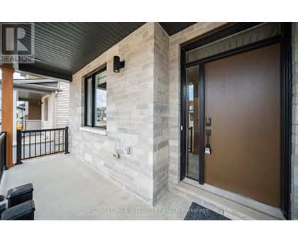 A modern house entrance with a glass door and a stone wall.