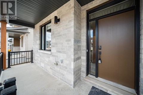 A modern house entrance with a glass door and a stone wall.