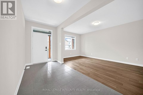 A spacious room with wooden flooring and a sliding glass door leading to a balcony.