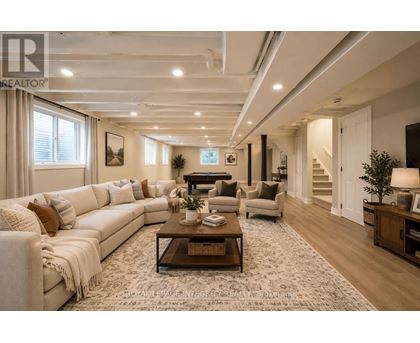 A spacious living room with a white sofa set and a coffee table.