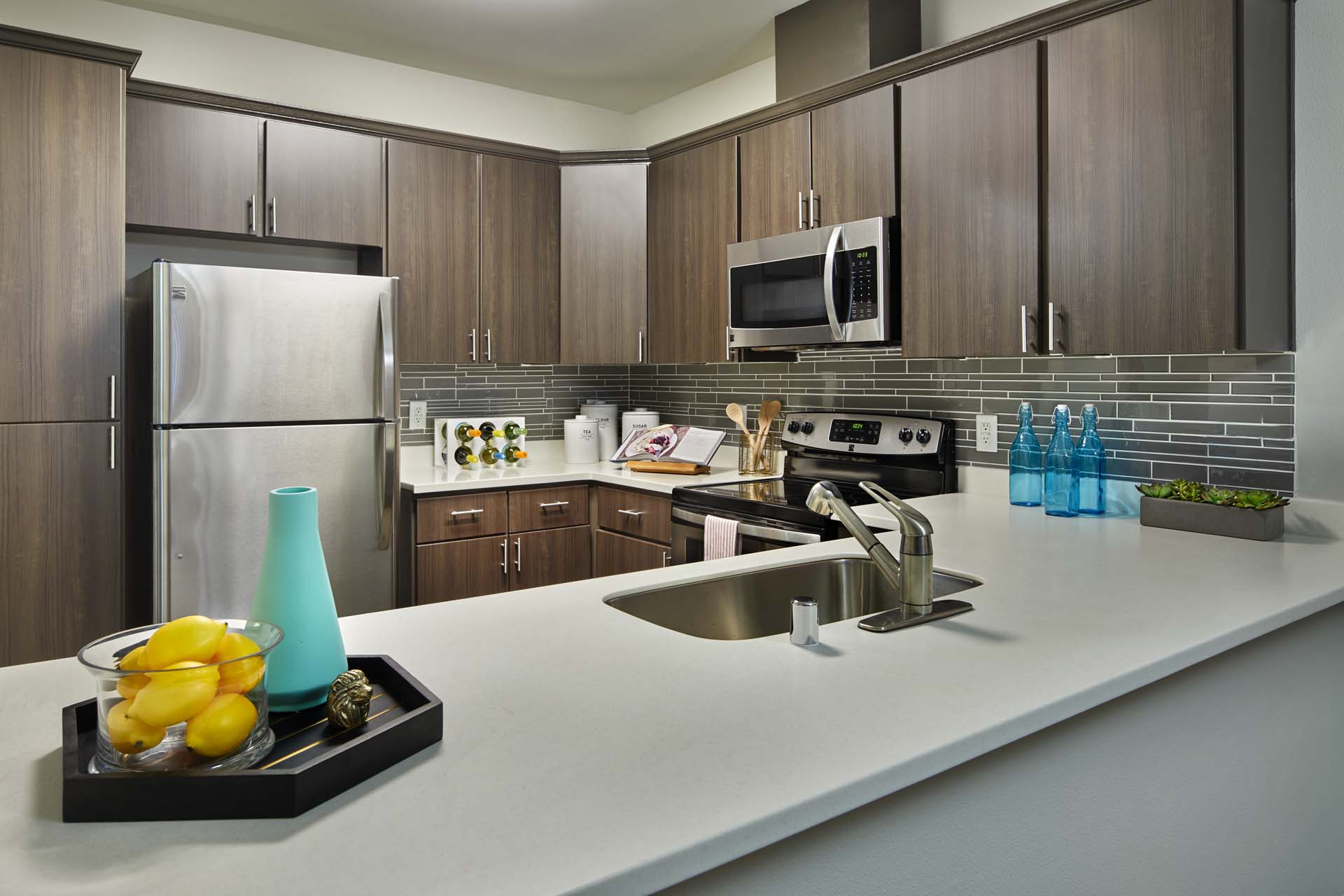 A kitchen with a white counter top and brown cabinets.