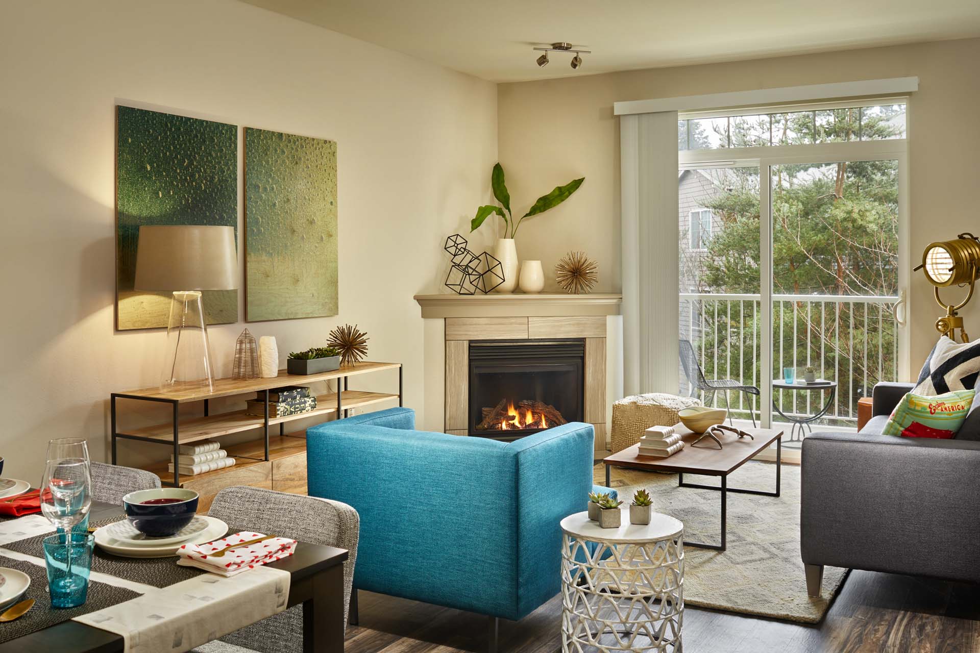 A modern living room with a fireplace and a dining table set for two.