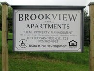 A sign for Brookview Apartments is displayed in a grassy area.