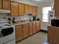 A kitchen with wooden cabinets and a white stove.