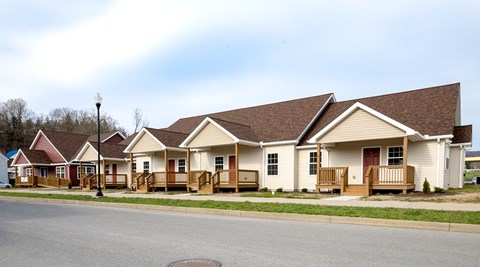 A row of houses with brown roofs and white walls.
