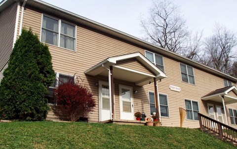 A house with a brown siding and a white door.