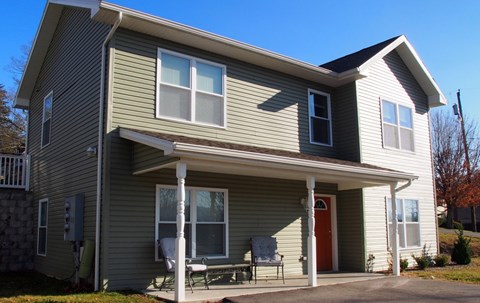 A house with a red door and a covered porch.