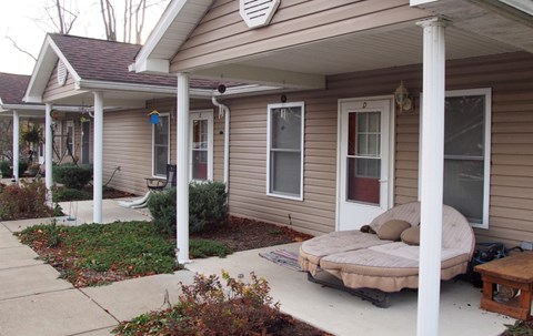 A house with a porch and a mattress on it.