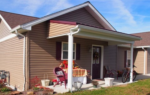 A house with a covered front porch and a red chair.