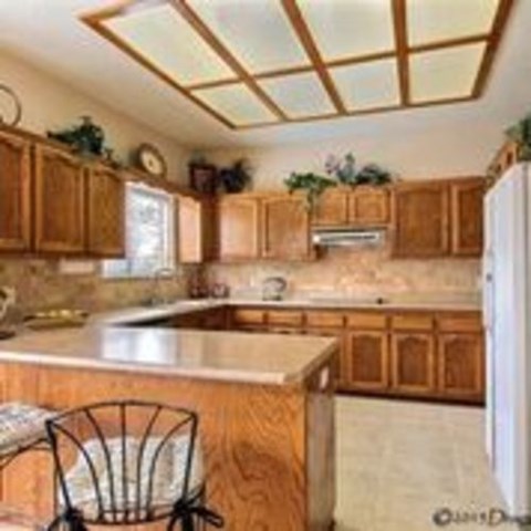 A kitchen with wooden cabinets and a marble countertop.
