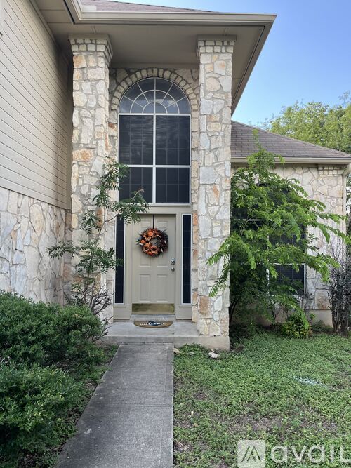 A house with a grey door and a wreath on it.
