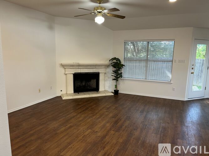 A room with a fireplace and a ceiling fan.