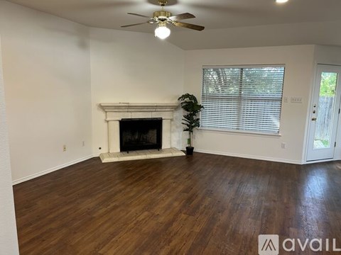 A room with a fireplace and a ceiling fan.