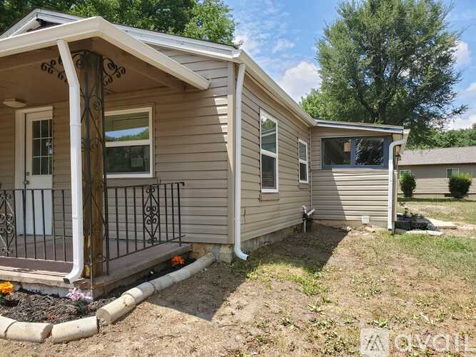 A small house with a porch and a small garden in front.