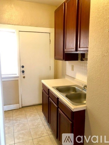 A kitchen with brown cabinets and a white door.