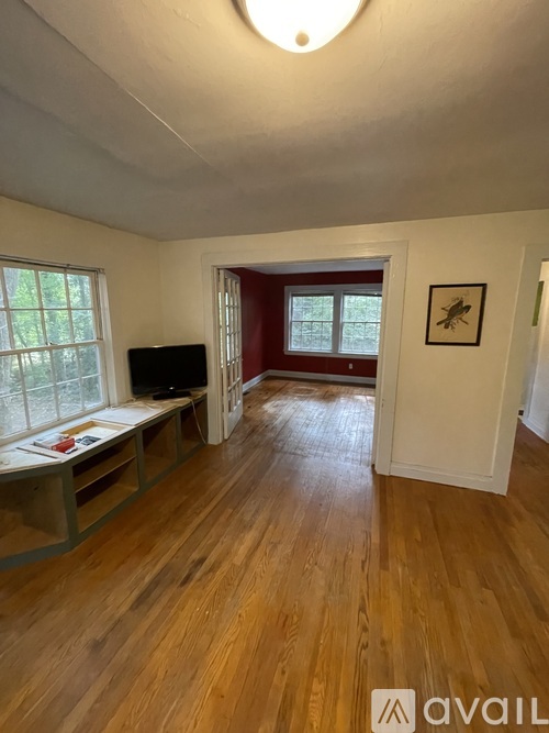 A room with wooden floors and a television set.