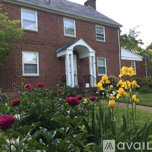 A red brick house with a white door and windows.