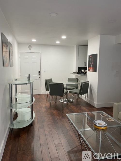 A modern kitchen with a glass table and chairs.