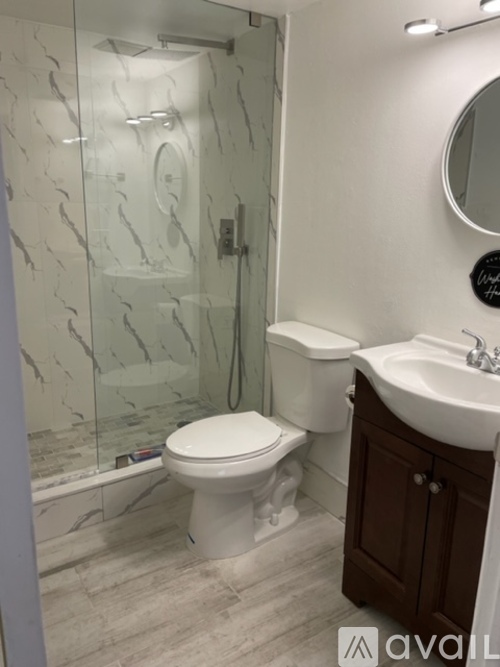 A white toilet sits in a bathroom next to a sink.