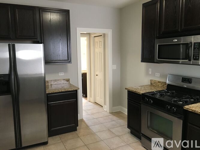A kitchen with black cabinets and stainless steel appliances.