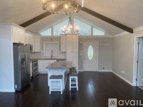 A kitchen with white cabinets and a wooden floor.