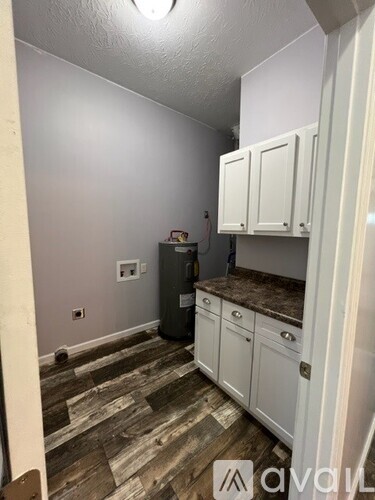 A kitchen with white cabinets and a wooden floor.